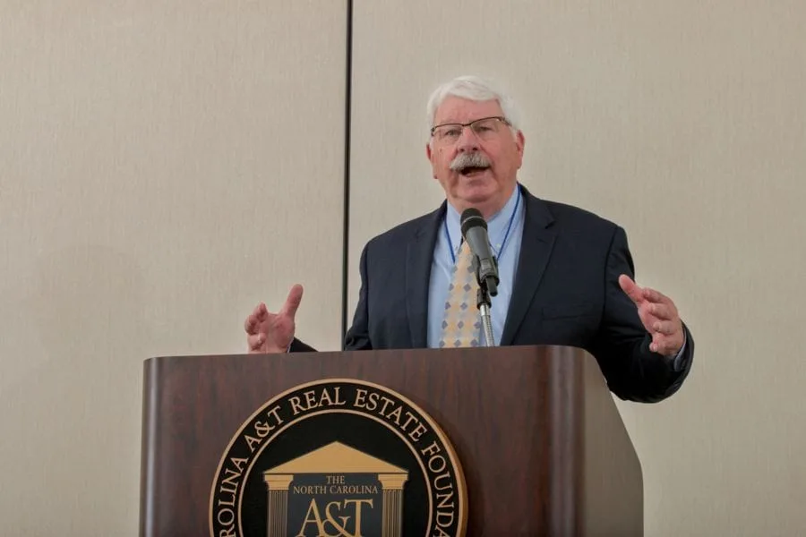 A man speaking at a podium during a conference or event.