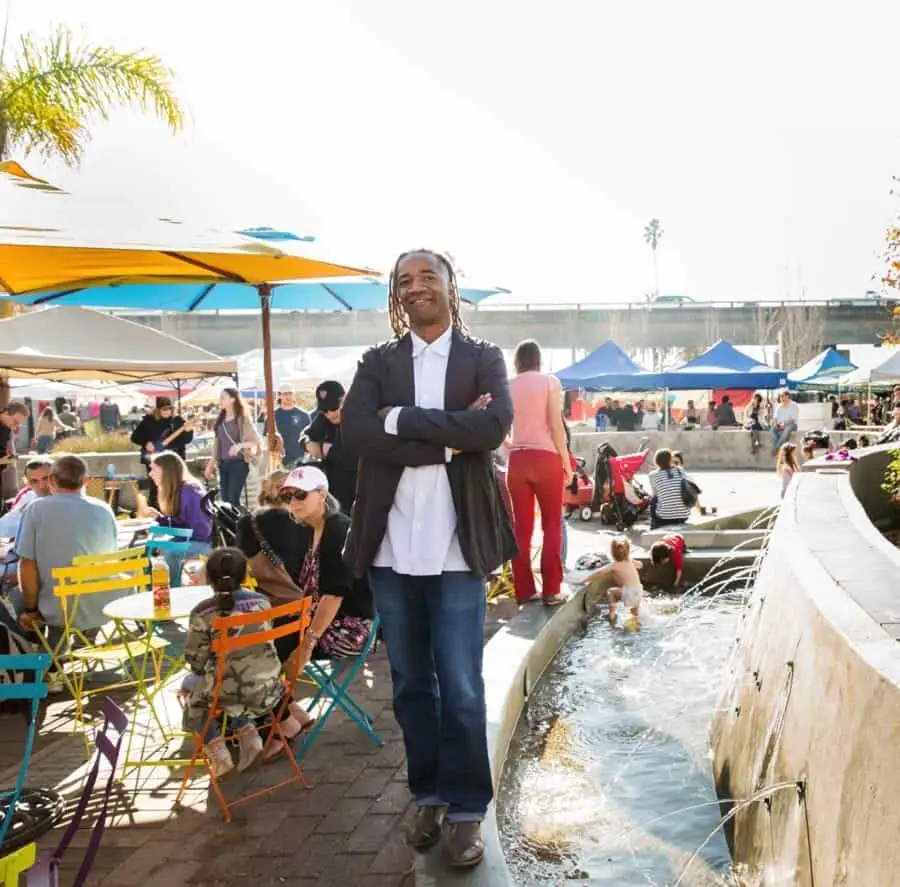Enjoying a sunny day at an outdoor event with colorful seating, water features, and a lively crowd.