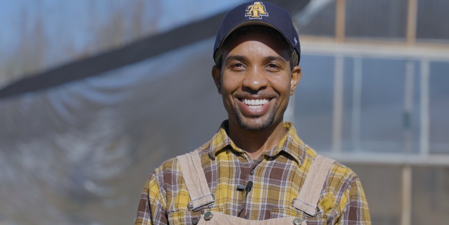 A smiling man wearing an A&T Ball cap