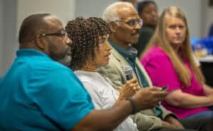 Diverse group of people participating in a community discussion or meeting.