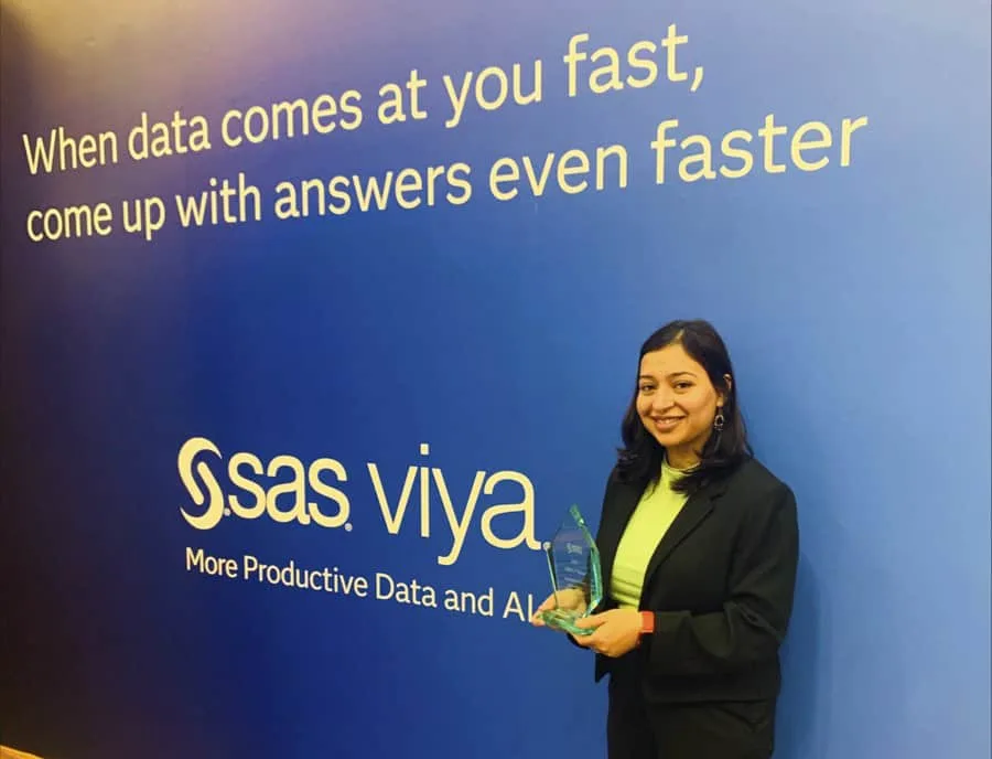 Fast data analysis and AI solutions at CAES News event with a smiling woman holding an award.