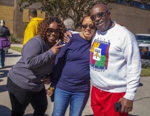 Group of diverse smiling people outdoors at a community event in casual attire.