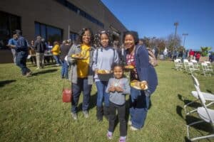 Family enjoying outdoor event with food on a sunny day at CAES News.