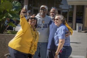 Celebrating diversity and friendship outside CAES News office in sunny weather.