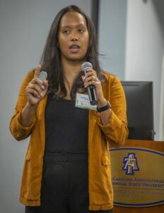 Empowered woman speaking at conference on agriculture and technology.