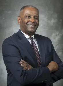 Portrait of M. Ray McKinnie, Cooperative Extension leader, smiling in a suit and tie