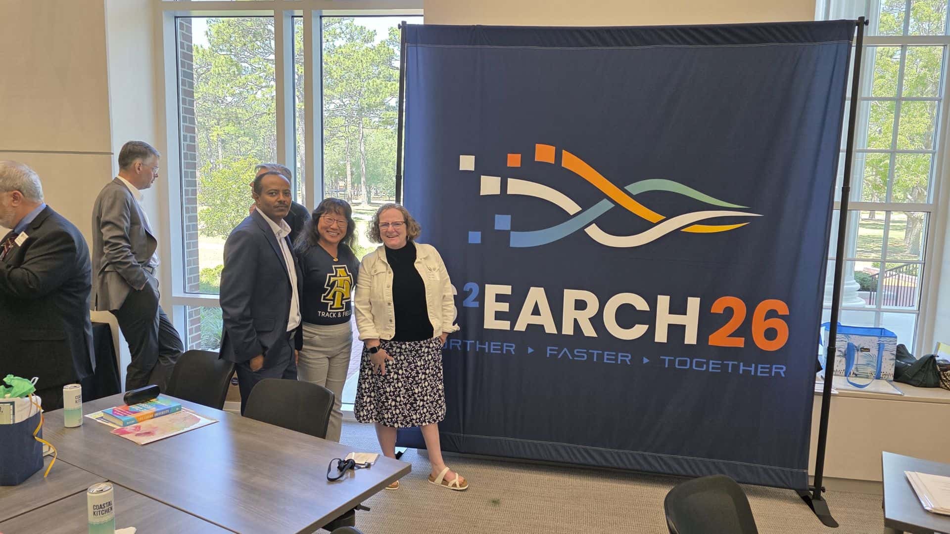Group of professionals at CAES News event with banner in background.