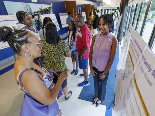 Group of diverse people at an indoor event engaging with informational displays.