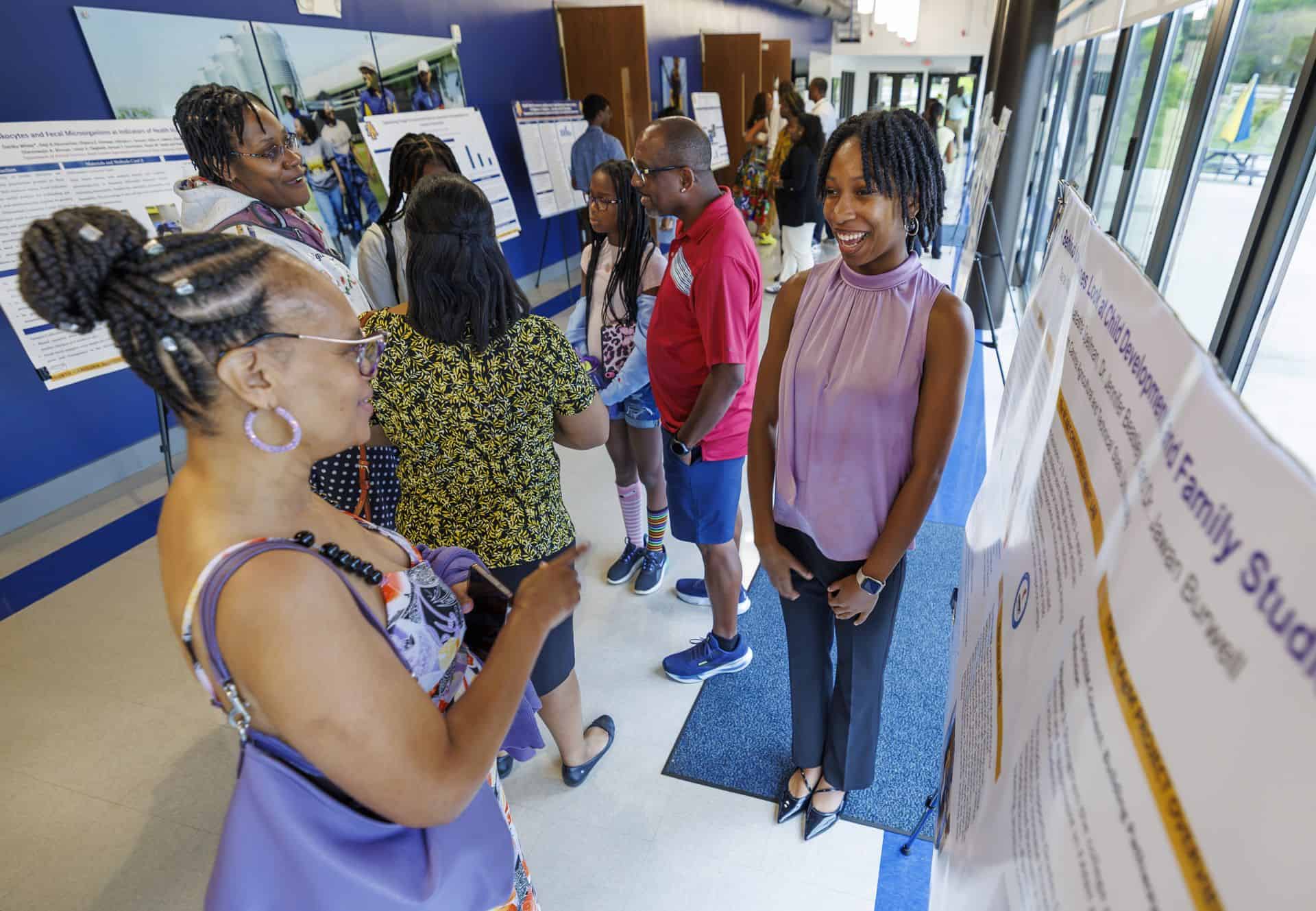 Group of diverse people at an indoor event engaging with informational displays.